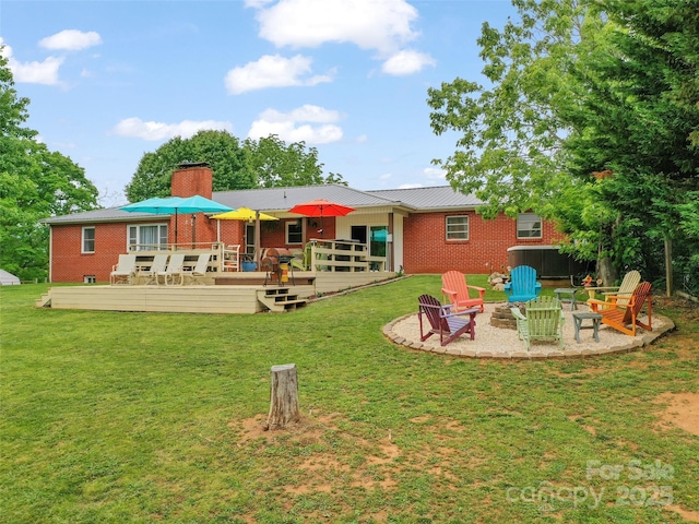 391 Ellen Ave, Canton, NC 28716 - rear view of house featuring brick siding, an outdoor fire pit, a deck, a lawn, and a chimney