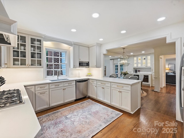 2919 Wickersham Rd, Charlotte, NC 28211 - kitchen featuring stainless steel appliances, a sink, a peninsula, white cabinetry, and dark wood-type flooring
