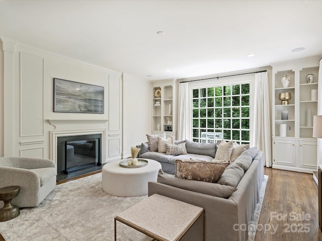 2919 Wickersham Rd, Charlotte, NC 28211 - living area featuring wood finished floors, built in features, and a glass covered fireplace