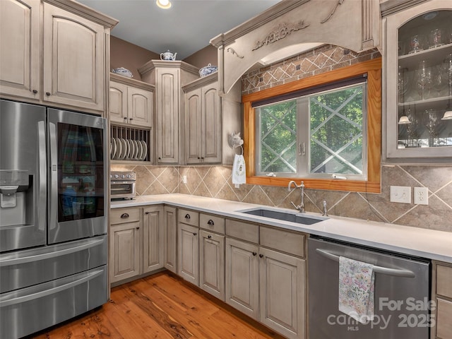 92 Island View Ct, Mill Spring, NC 28756 - kitchen with appliances with stainless steel finishes, a sink, light countertops, glass insert cabinets, and backsplash