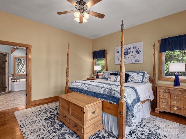 92 Island View Ct, Mill Spring, NC 28756 - bedroom featuring wood finished floors, ensuite bath, baseboards, and a ceiling fan