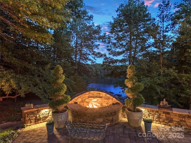 92 Island View Ct, Mill Spring, NC 28756 - view of patio with a forest view, a water view, and an outdoor fire pit