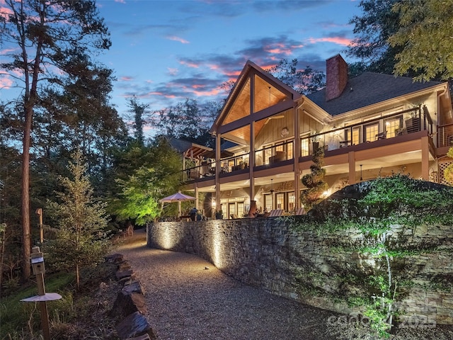 92 Island View Ct, Mill Spring, NC 28756 - back of property at dusk featuring a balcony and a chimney