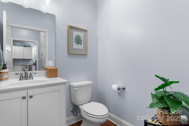 1067 33rd Avenue Loop NE, Hickory, NC 28601 - bathroom featuring toilet, vanity, wood finished floors, decorative backsplash, and baseboards