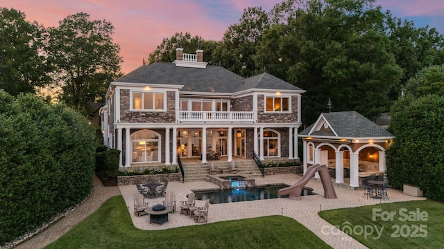 123 Sailview Rd, Mooresville, NC 28117 - rear view of house with stone siding, a patio area, a chimney, and a storage structure
