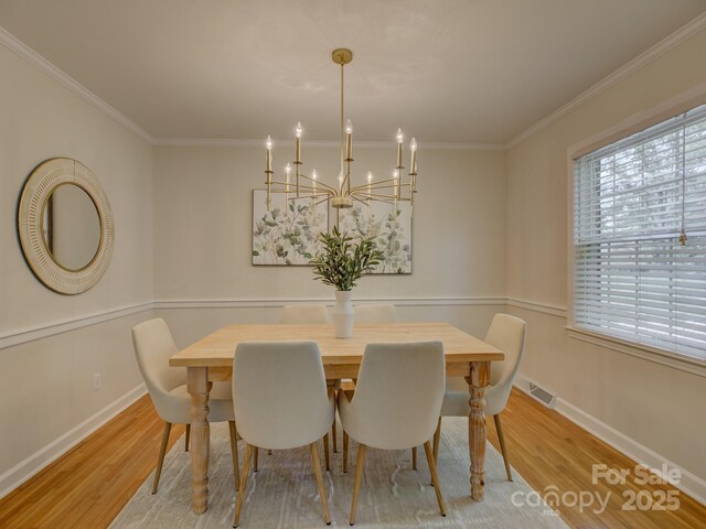 6116 Springhouse Ln, Charlotte, NC 28211 - dining room with light wood-style flooring, crown molding, and a chandelier