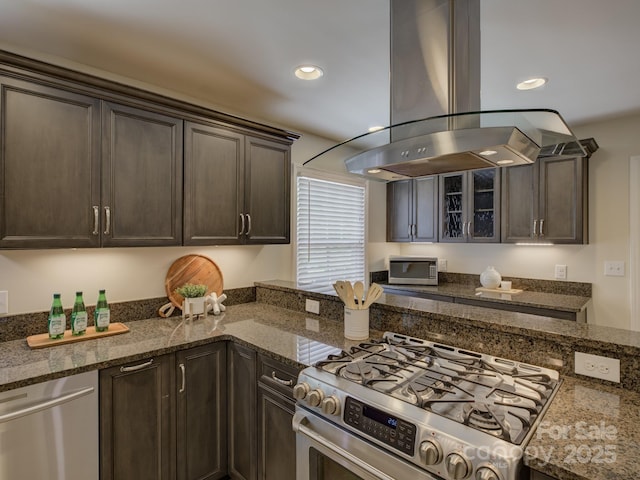 6116 Springhouse Ln, Charlotte, NC 28211 - kitchen with island range hood, stainless steel appliances, dark brown cabinets, dark stone countertops, and recessed lighting
