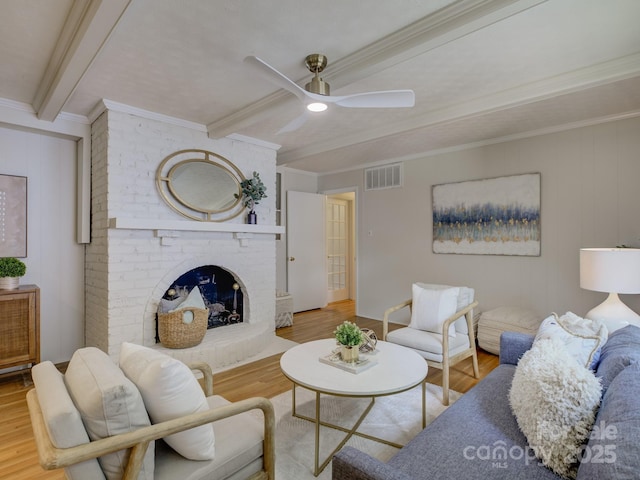 6116 Springhouse Ln, Charlotte, NC 28211 - living area with beam ceiling, wood finished floors, ceiling fan, a brick fireplace, and crown molding