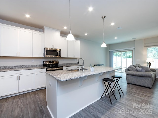 403 Park Meadows Dr, Matthews, NC 28104 - kitchen with appliances with stainless steel finishes, a sink, dark wood-type flooring, a breakfast bar, and white cabinets