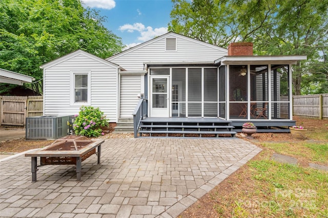 34 Admiral Ave SW, Concord, NC 28027 - back of property featuring a sunroom, a patio, an outdoor fire pit, a chimney, and central air condition unit