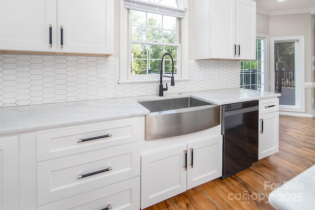 6400 Morningsong Ln, Charlotte, NC 28269 - kitchen featuring dishwasher, backsplash, crown molding, white cabinetry, and light wood finished floors