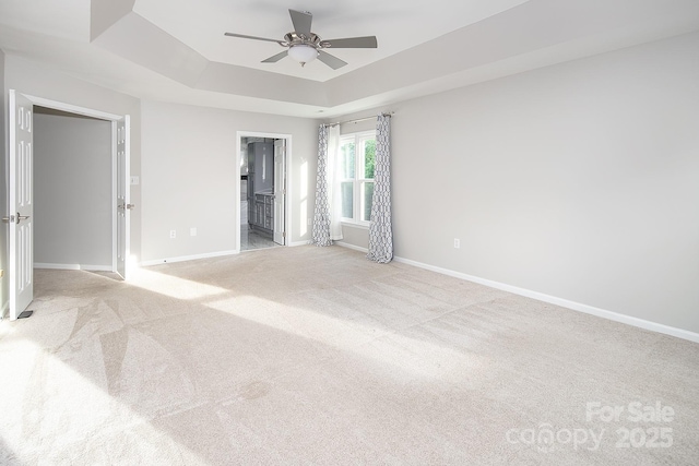 6400 Morningsong Ln, Charlotte, NC 28269 - unfurnished bedroom with a tray ceiling, light colored carpet, ensuite bathroom, and ceiling fan