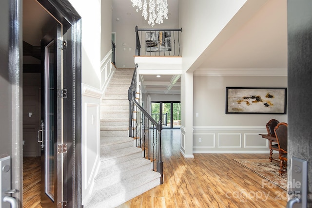 6400 Morningsong Ln, Charlotte, NC 28269 - entryway with crown molding, stairway, wood finished floors, a chandelier, and coffered ceiling