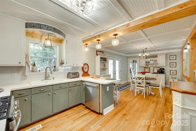 504 Amon Ln, Pineville, NC 28134 - kitchen featuring a peninsula, appliances with stainless steel finishes, a sink, light wood-style flooring, and decorative backsplash