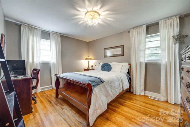 504 Amon Ln, Pineville, NC 28134 - bedroom with multiple windows, baseboards, light wood-style floors, and a desk