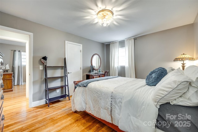 504 Amon Ln, Pineville, NC 28134 - bedroom featuring multiple windows, light wood finished floors, and baseboards