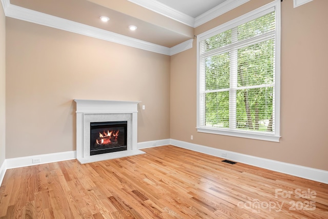 3204 Mcpherson St, Waxhaw, NC 28173 - unfurnished living room featuring plenty of natural light, a glass covered fireplace, ornamental molding, wood finished floors, and baseboards