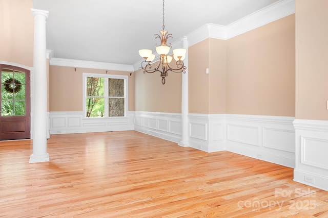 3204 Mcpherson St, Waxhaw, NC 28173 - empty room featuring a wainscoted wall, a chandelier, light wood-type flooring, ornamental molding, and ornate columns