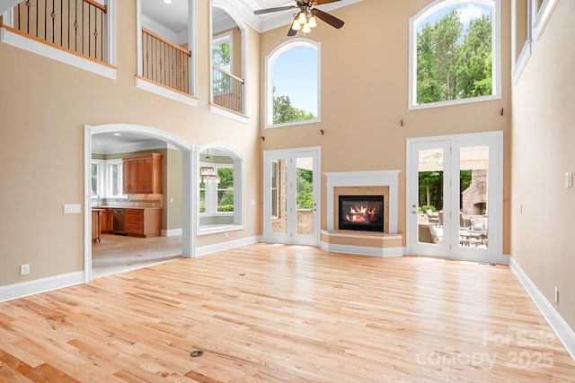 3204 Mcpherson St, Waxhaw, NC 28173 - unfurnished living room with ornamental molding, a ceiling fan, light wood finished floors, healthy amount of natural light, and a towering ceiling