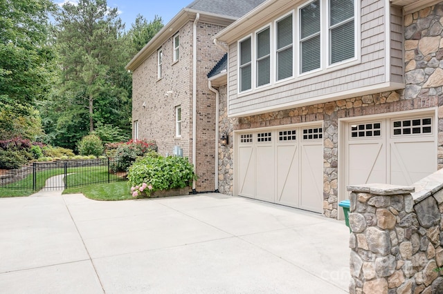 3204 Mcpherson St, Waxhaw, NC 28173 - view of side of property with driveway, stone siding, and an attached garage