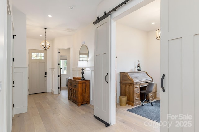 40 Hidden Pond Ln, Brevard, NC 28712 - entrance foyer with light wood-style flooring, a chandelier, a barn door, recessed lighting, and a wainscoted wall