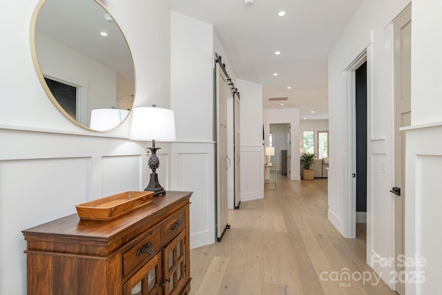 40 Hidden Pond Ln, Brevard, NC 28712 - hallway with a barn door, light wood-style flooring, recessed lighting, wainscoting, and a decorative wall