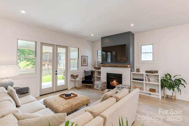 40 Hidden Pond Ln, Brevard, NC 28712 - living room featuring french doors, recessed lighting, light wood-type flooring, and a glass covered fireplace