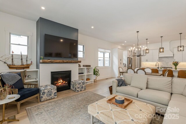 40 Hidden Pond Ln, Brevard, NC 28712 - living area with light wood-style floors, a glass covered fireplace, recessed lighting, a chandelier, and baseboards
