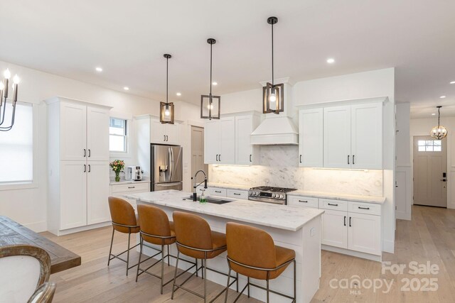 40 Hidden Pond Ln, Brevard, NC 28712 - kitchen with a sink, appliances with stainless steel finishes, a breakfast bar area, a kitchen island with sink, and healthy amount of natural light