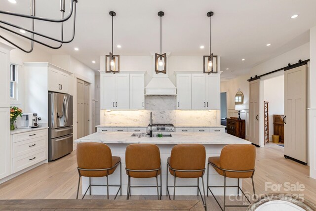 40 Hidden Pond Ln, Brevard, NC 28712 - kitchen featuring appliances with stainless steel finishes, a barn door, tasteful backsplash, light wood-style floors, and recessed lighting