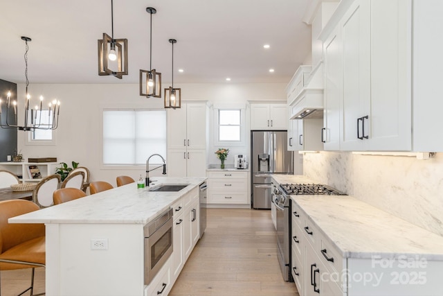 40 Hidden Pond Ln, Brevard, NC 28712 - kitchen with appliances with stainless steel finishes, a breakfast bar area, a chandelier, a sink, and light wood-style floors