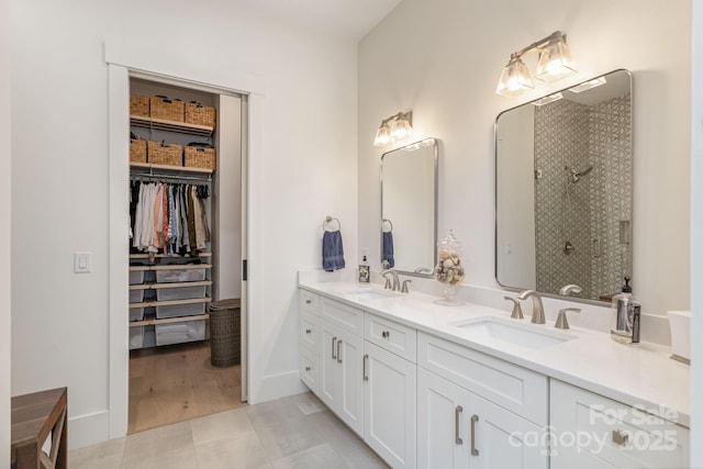 40 Hidden Pond Ln, Brevard, NC 28712 - full bathroom featuring double vanity, a tile shower, a walk in closet, and baseboards