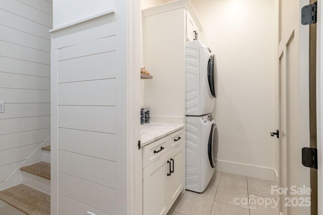 40 Hidden Pond Ln, Brevard, NC 28712 - laundry room featuring stacked washer / dryer, cabinet space, and light tile patterned flooring