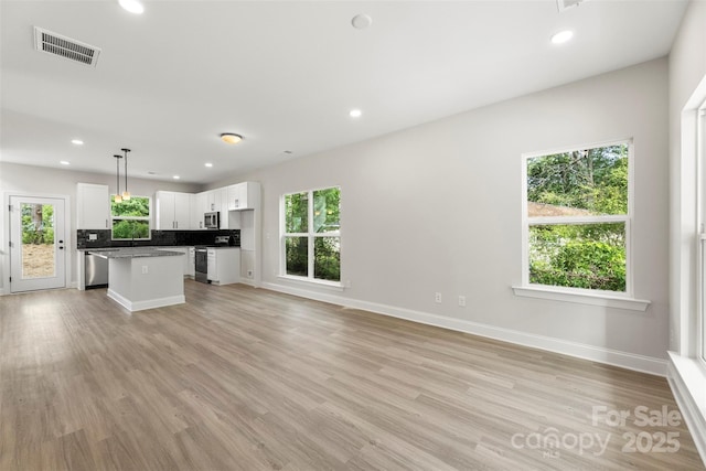 105 Spring Garden Dr, Gastonia, NC 28052 - unfurnished living room featuring baseboards, light wood-style floors, recessed lighting, and a sink