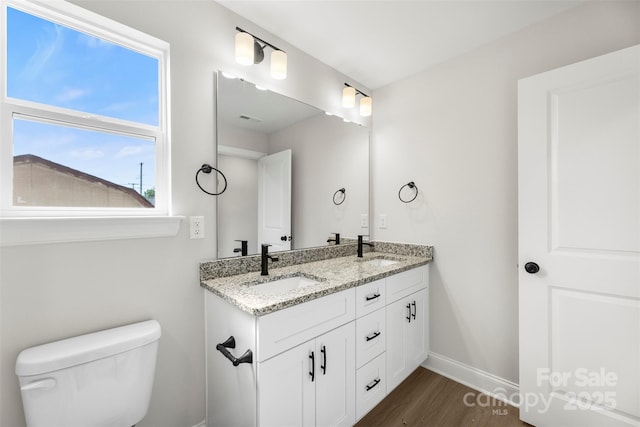 105 Spring Garden Dr, Gastonia, NC 28052 - bathroom featuring wood finished floors, double vanity, toilet, and baseboards