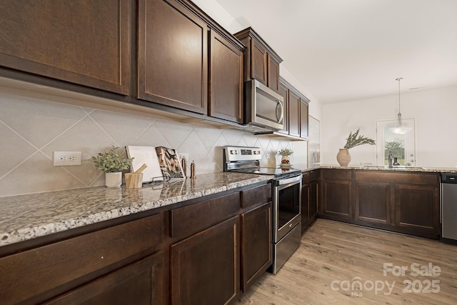 124 Canada Dr Unit 45, Statesville, NC 28166 - kitchen featuring stainless steel appliances, dark brown cabinetry, tasteful backsplash, light wood-style flooring, and light stone countertops