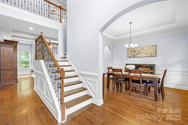 2289 Pine Valley Dr, Denver, NC 28037 - dining space with arched walkways, ornamental molding, stairway, wood finished floors, and a tray ceiling