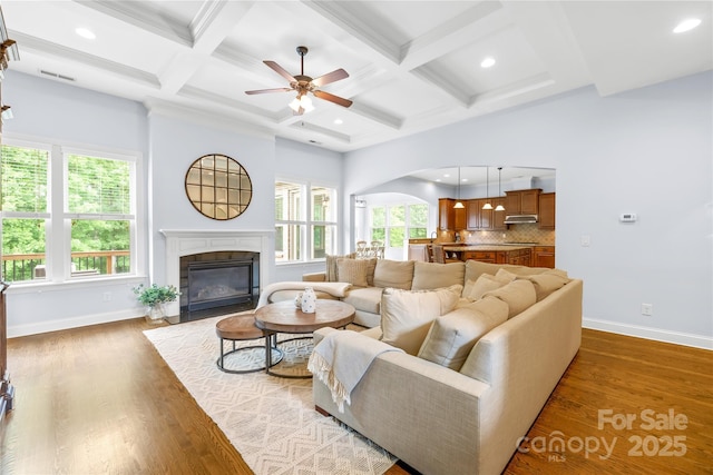 2289 Pine Valley Dr, Denver, NC 28037 - living area with ceiling fan, baseboards, coffered ceiling, arched walkways, and a fireplace with flush hearth