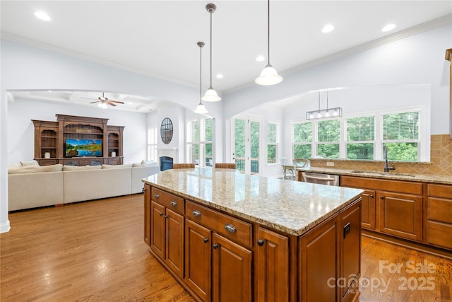 2289 Pine Valley Dr, Denver, NC 28037 - kitchen featuring a sink, a fireplace, stainless steel dishwasher, brown cabinets, and arched walkways
