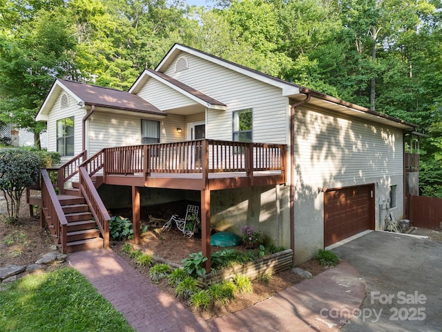100 Tarragon Pl, Flat Rock, NC 28731 - view of front of home featuring a wooden deck, driveway, an attached garage, and stairs