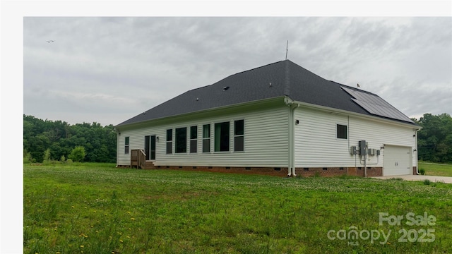 4710 Old Pageland Marshville Rd, Monroe, NC 28112 - back of property featuring crawl space, a garage, a lawn, roof mounted solar panels, and concrete driveway