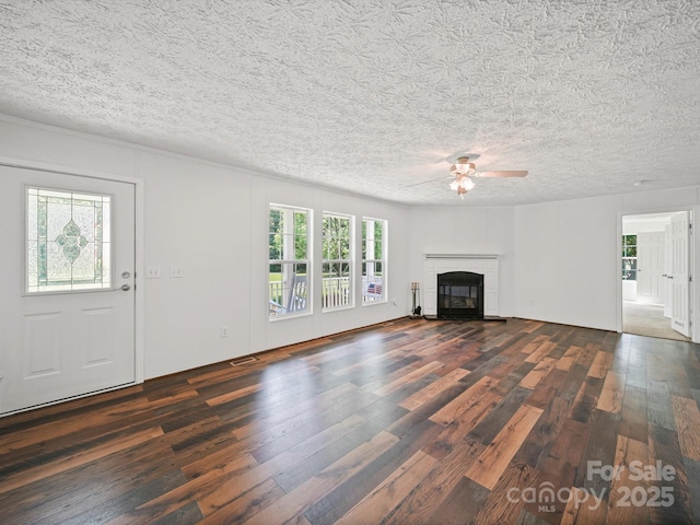 714 Helms Efird Rd, Marshville, NC 28103 - unfurnished living room with dark wood-type flooring, a ceiling fan, a textured ceiling, and a tile fireplace