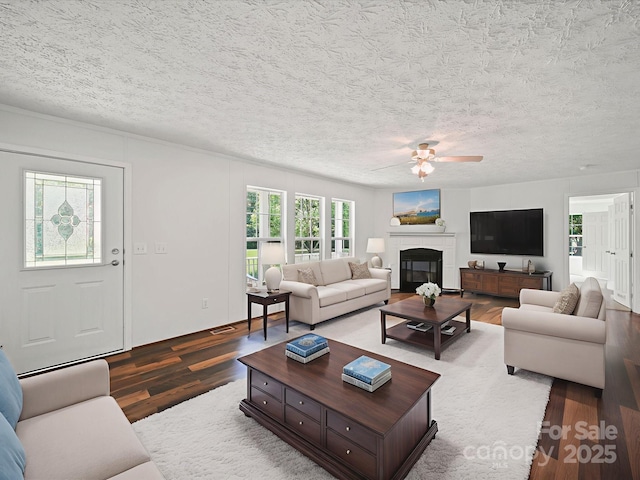 714 Helms Efird Rd, Marshville, NC 28103 - living area with wood finished floors, ceiling fan, a glass covered fireplace, and a textured ceiling