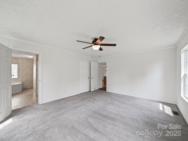 714 Helms Efird Rd, Marshville, NC 28103 - unfurnished bedroom featuring carpet flooring, a textured ceiling, ceiling fan, ensuite bath, and crown molding