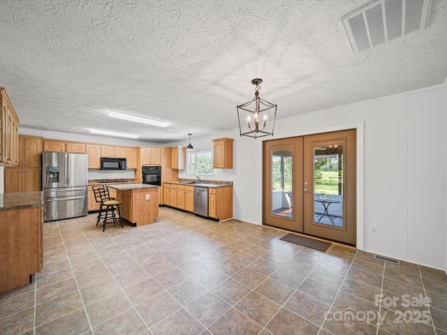 714 Helms Efird Rd, Marshville, NC 28103 - kitchen featuring black appliances, a chandelier, a center island, french doors, and a kitchen breakfast bar
