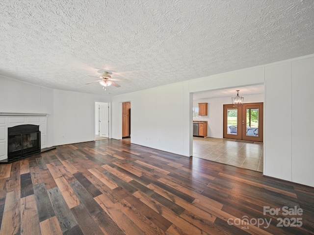 714 Helms Efird Rd, Marshville, NC 28103 - unfurnished living room featuring wood finished floors, a chandelier, a glass covered fireplace, ceiling fan, and a textured ceiling