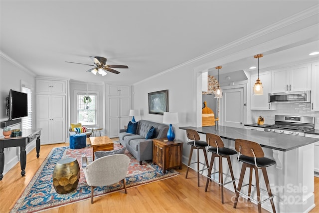 1729 Kensington Dr, Charlotte, NC 28205 - living room featuring light wood-style flooring, ceiling fan, ornamental molding, and baseboards
