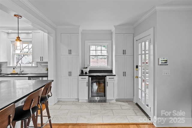 1729 Kensington Dr, Charlotte, NC 28205 - kitchen featuring beverage cooler, a sink, light marble finish floors, white cabinets, and decorative backsplash