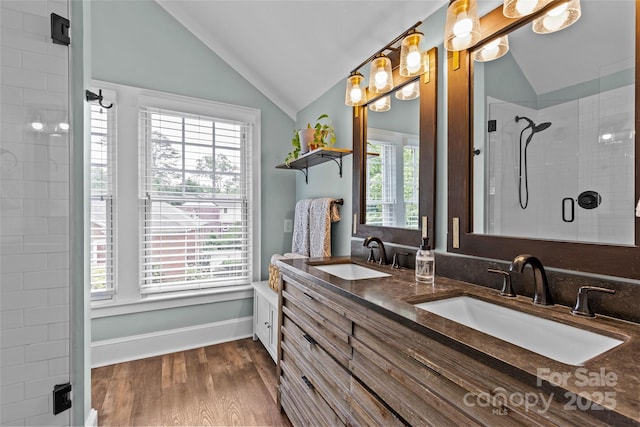 1729 Kensington Dr, Charlotte, NC 28205 - full bathroom with vaulted ceiling, double vanity, a tile shower, wood finished floors, and baseboards