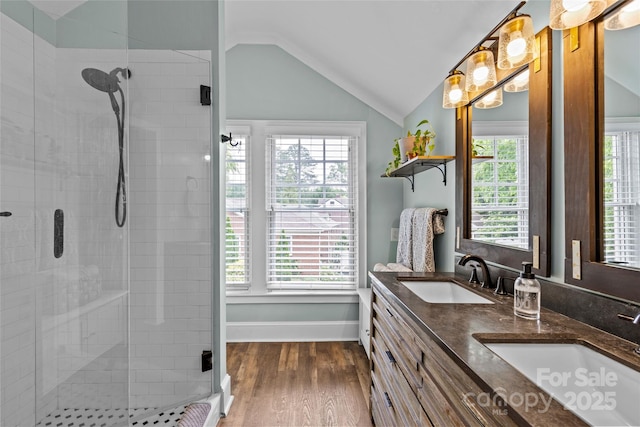 1729 Kensington Dr, Charlotte, NC 28205 - bathroom with a shower stall, lofted ceiling, double vanity, plenty of natural light, and wood finished floors